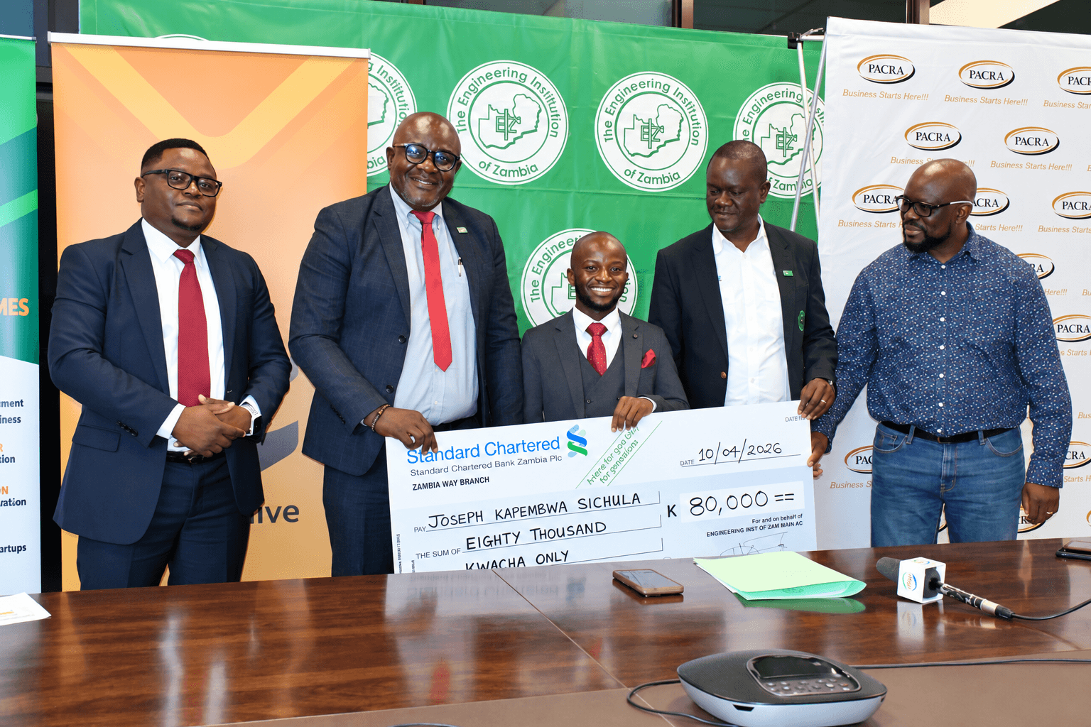 Joseph Sichula receiving a K80,000 grant cheque with Engineering Institution of Zambia leaders